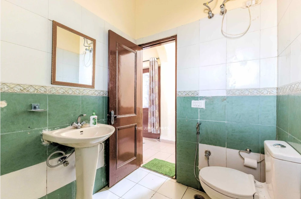 Bathroom with basin, shower and green tiles